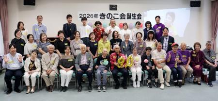 　「きのこ会」の誕生会で、写真に納まる原爆小頭症の被爆者と家族ら＝２０日午後、広島市