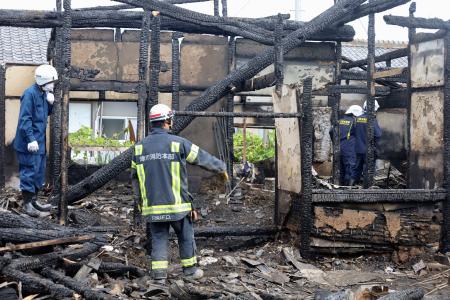 　住宅火災の焼け跡で実況見分をする警察官と消防隊員＝３日午前、津市