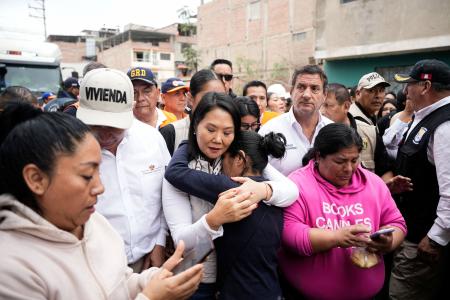 　ペルー・リマの豪雨被害が出た地域で、女性と抱き合うケイコ・フジモリ大統領（手前中央）＝１７日（ロイター＝共同）