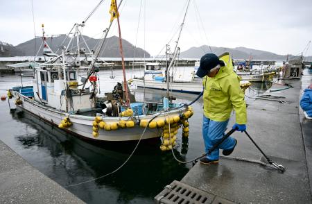 　地震から一夜明け、カキいかだの確認と作業のため、出港準備をする漁師＝２１日午前、岩手県大船渡市