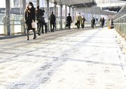 雪が積もった箇所を避けて歩く人たち＝岐阜市橋本町、ＪＲ岐阜駅前