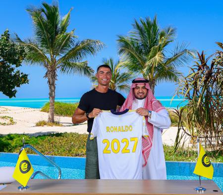 　アルナスルと２０２７年まで契約を延長し、紅海を背景にアルマジード・チェアマン（右）と笑顔を見せるロナルド＝２６日（ロイター＝共同）