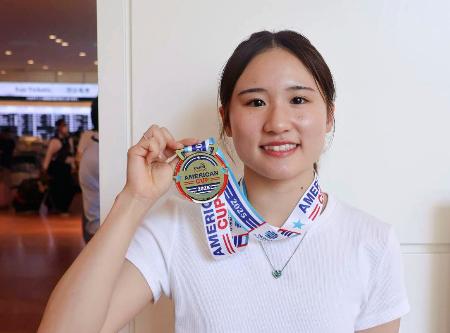 　米国遠征から帰国し、金メダルを手にする女子高飛び込み世界選手権代表の金戸凜＝１７日、羽田空港