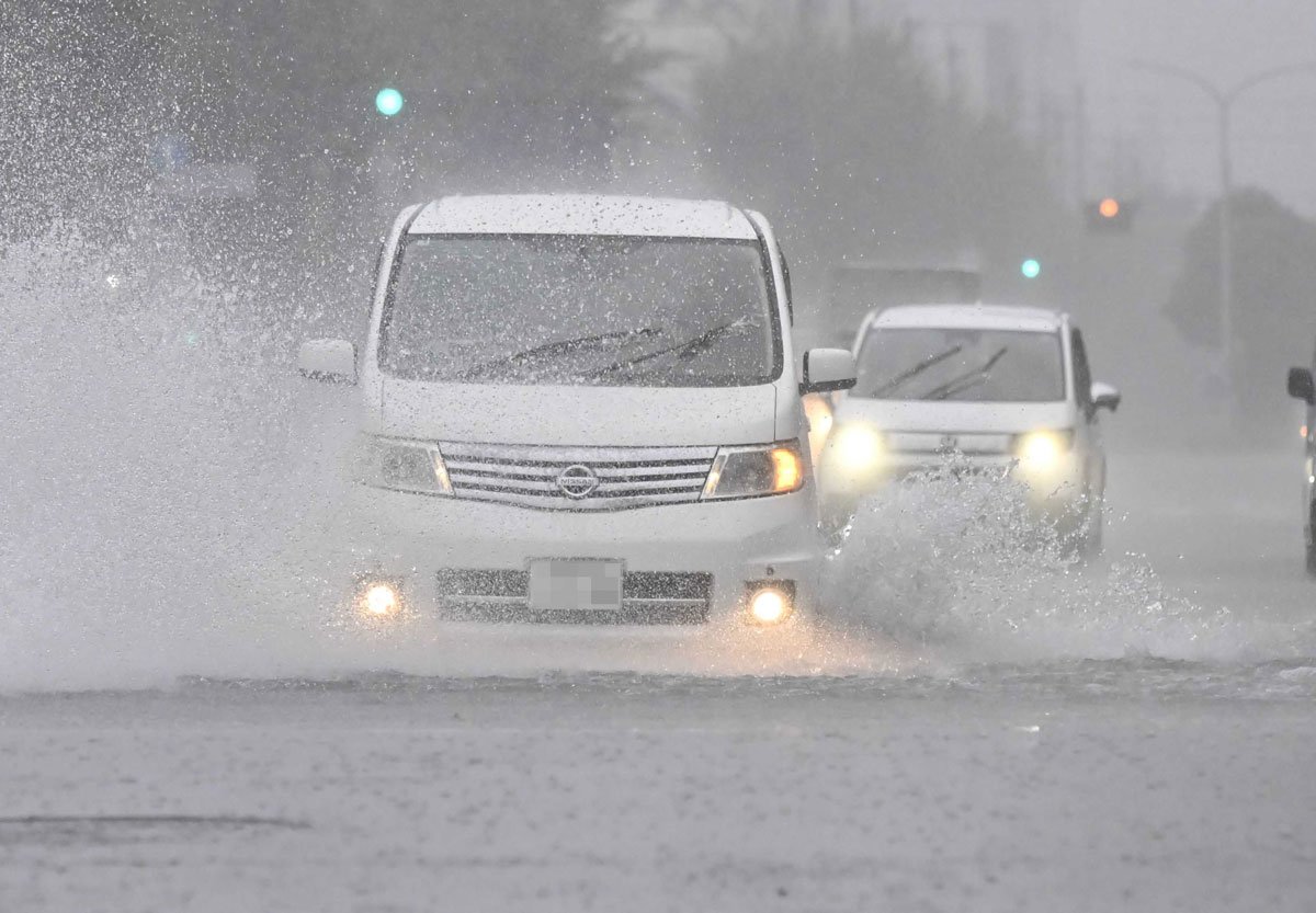 一部が冠水した道路を走る車（一部画像加工）＝８日午後３時３８分、岐阜市神田町（撮影・堀尚人）