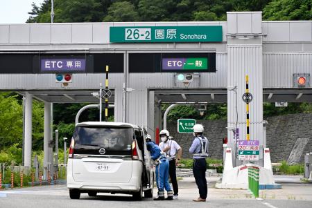 　中央自動車道逆走事故の実況見分で、警察車両に乗せた９９歳男性に話しかける岐阜県警高速隊員＝２７日午前、長野県阿智村