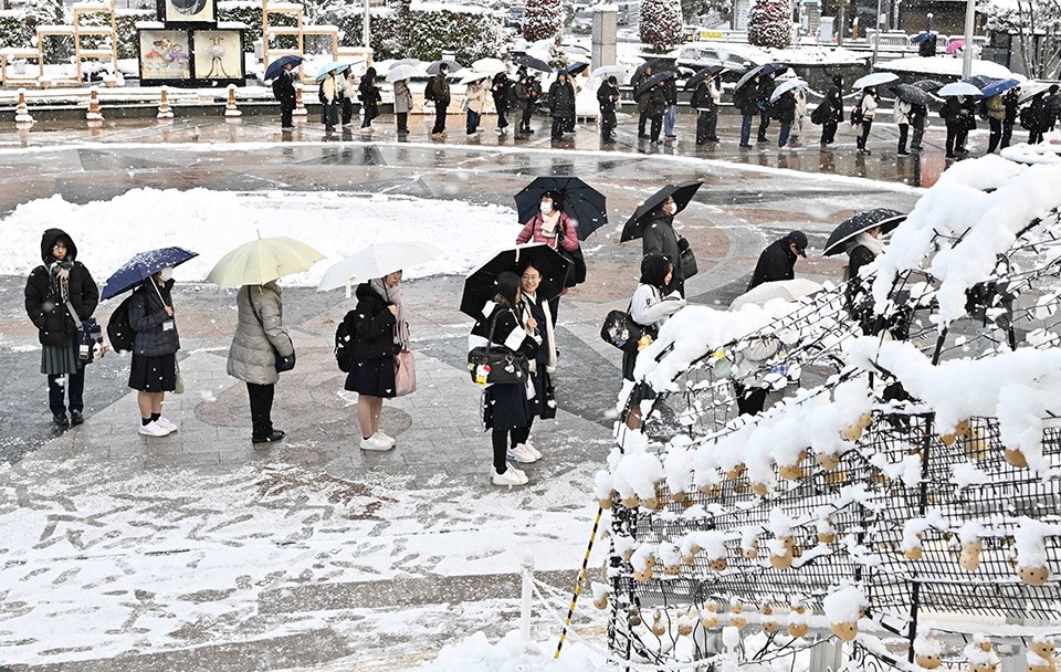 雪の中でバスを待つ人たち＝２３日午前７時１８分、岐阜市橋本町、ＪＲ岐阜駅北口（撮影・堀尚人）