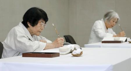 　原爆死没者名簿に記帳する中本信子さん（左）と大川純子さん＝２日午前、広島市役所