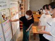 高校生に促され、夏限定ソフトクリームを食べた感想をシール投票する女性（左）＝美濃加茂市太田町、まちベンチ美濃太田ラボ