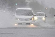 一部が冠水した道路を走る車（一部画像加工）＝８日午後３時３８分、岐阜市神田町（撮影・堀尚人）