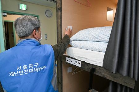 　１６日、ソウル市内のカプセルホテルの安全点検を行う区の関係者（共同）