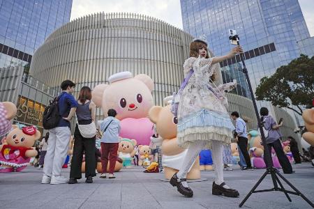 　商業施設の前で自撮りをする人＝５月、中国上海市