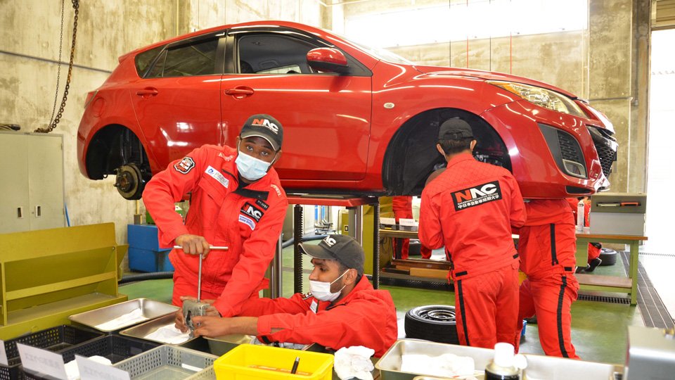 自動車整備実習でブレーキの点検に取り組む学生たち＝同町深萱、中日本自動車短大