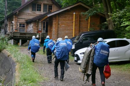 　羅臼岳登山口に向かう捜索隊＝１５日午前４時４３分、北海道斜里町