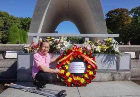 　原爆慰霊碑に献花するグエン・ドクさん＝９日午前、広島市の平和記念公園