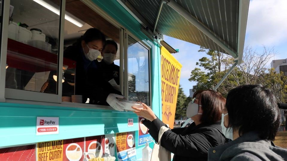 キッチンカーでカレーライスを買い求める女性＝岐阜市司町