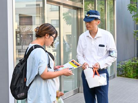 　ＪＲ摩耶駅前でチラシを配り、情報提供を求める警察官＝３１日午後、神戸市