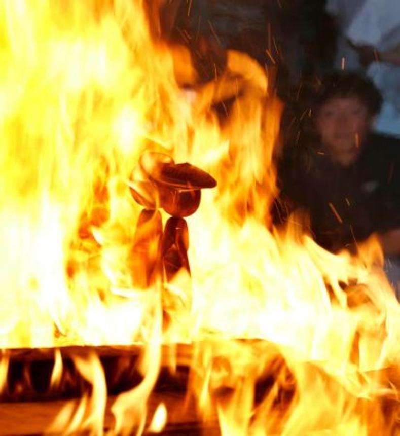　宮城県大崎市・鳴子温泉の神社で開かれた「こけし供養祭」で炎に包まれるこけし＝５日午後