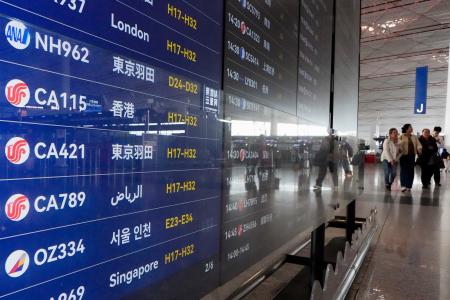 　北京首都空港の出発ロビーで羽田空港行きの便が表示された電光掲示板＝１５日（共同）