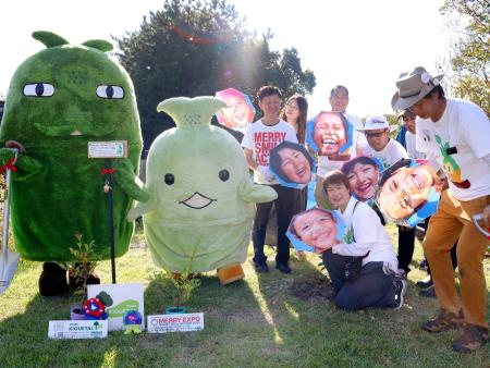 　愛・地球博記念公園で苗木を植え、「モリゾー」「キッコロ」と写真に納まる人たち＝１１日午後、愛知県長久手市