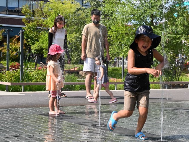 照りつけるような日差しの中、水遊びを楽しむ子どもたち＝８日午後２時５０分、多治見市音羽町、虎渓用水広場