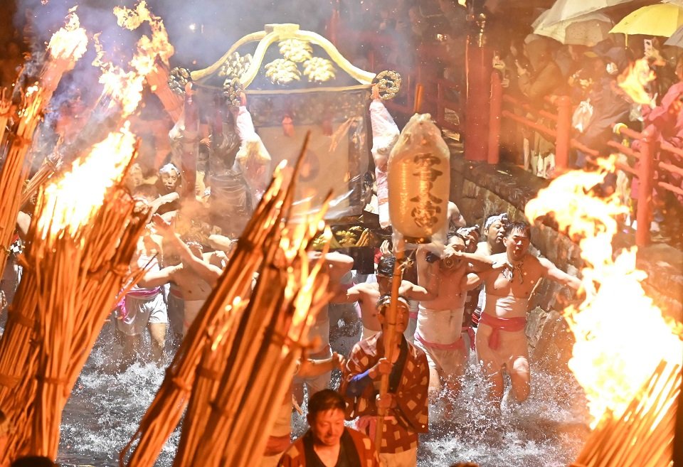 「朝渡御」で、たいまつに照らされて川を駆け抜けるみこし＝３０日午前０時４６分、安八郡神戸町神戸