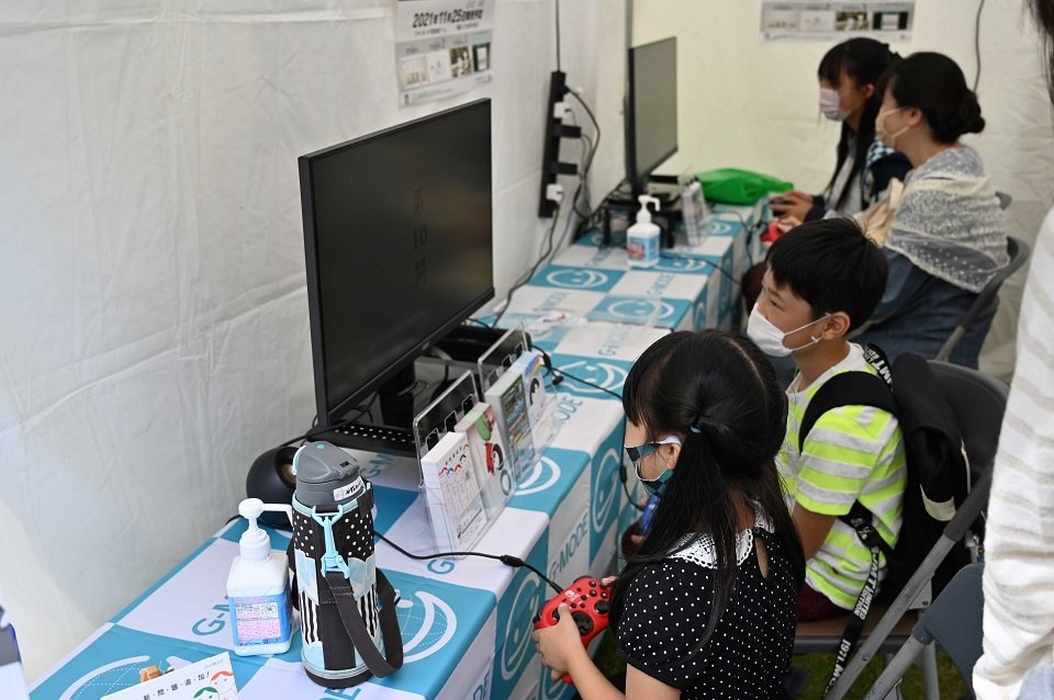 コントローラーを手に画面に向かう子どもたち＝２２日午後、各務原市那加門前町、市民公園
