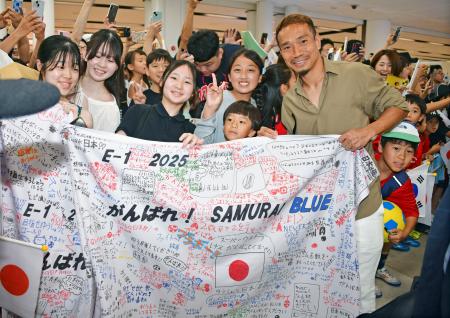 　６日、韓国・金浦空港でソウル日本人学校の児童生徒らと記念撮影に応じる長友佑都選手（右）（共同）