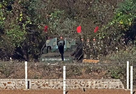 　２８日、韓国・京畿道金浦市の展望台で、対岸に見える北朝鮮の自走砲。そばには兵士らの姿もあった（共同）