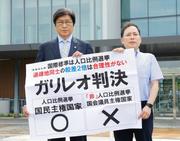 　衆院選「１票の格差」訴訟の判決後、名古屋高裁金沢支部前で判断を非難する紙を掲げる伊藤真弁護士（左）ら＝１７日午後