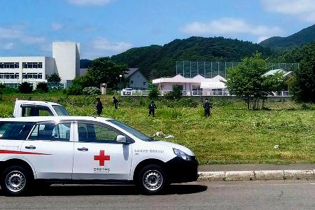 　ヒグマが逃げ込まないように草を刈る町職員ら＝１２日午後、北海道福島町