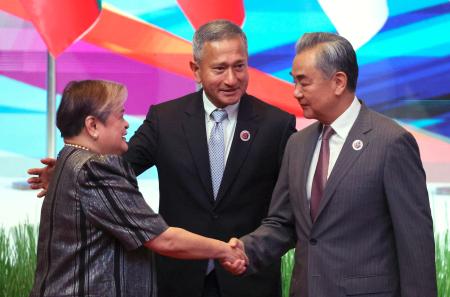 　中国ＡＳＥＡＮ外相会議で、フィリピンのラザロ外相（左）と握手する中国の王毅外相＝１０日、マレーシア・クアラルンプール（ＡＰ＝共同）