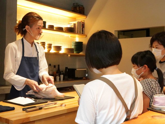 ミニツアーの参加者に鶏肉のさばき方を教える塚田幸佑さん（左）＝中津川市栄町、エレジア