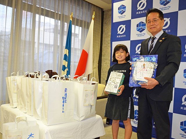 募金活動で購入した熱中症対策グッズなどを伊藤誠一市長へ寄贈した本田ゆり衣さん＝美濃加茂市役所