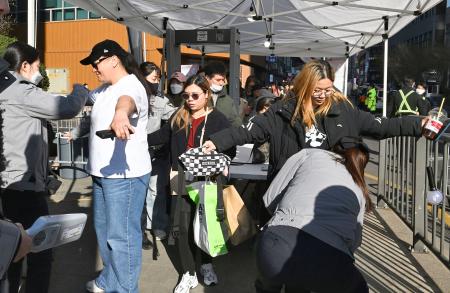 　韓国の人気音楽グループＢＴＳの公演会場で保安検査を受けるファンら＝２１日、ソウル（共同）