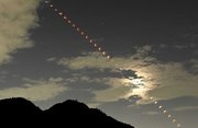 皆既月食が満月に戻っていく連続写真。左下は金華山＝８日未明、岐阜市内から望む（５分おきに撮影し比較明合成）