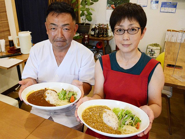 山下恵子さん（右）考案のカレーを手にする料理長の河野洋三さん＝大野町黒野、とくだ屋