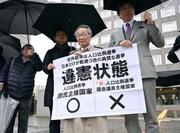 　「１票の格差」訴訟の判決を受け、札幌高裁前で「違憲状態」などと書かれた紙を掲げる原告側の升永英俊弁護士（右から２人目）ら＝１０日午後