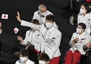 入場行進する車いすバスケットボールの秋田啓選手（中央）＝２４日夜、国立競技場