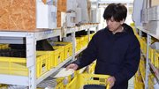 人気シリーズ「リンカ」を手に発送の準備をする伊藤祐輝専務＝土岐市下石町、カネコ小兵製陶所