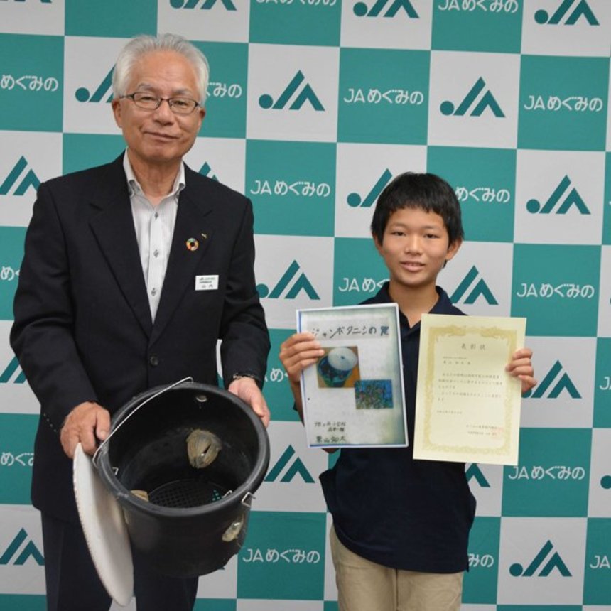ジャンボタニシの捕獲装置を考案し、山内清久組合長から感謝状を受け取った栗山知大君＝関市若草通、ＪＡめぐみの本店