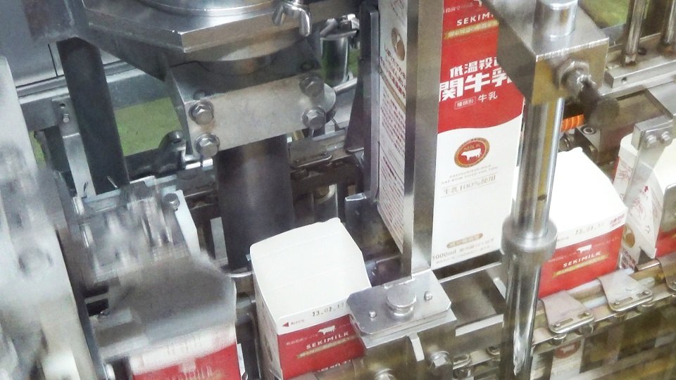生産ラインでは次々とパックの中に牛乳が充てんされていく＝関市観音前、関牛乳