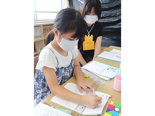 学生の指導を受け、宿題に取り組む小学生＝岐阜市粟野東、岩野田児童センター
