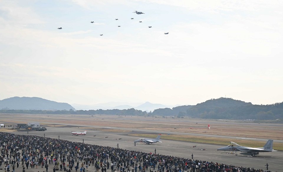 羽を広げた鵜をイメージした隊形で飛行する異機種大編隊＝１３日午前８時５１分、各務原市、航空自衛隊岐阜基地