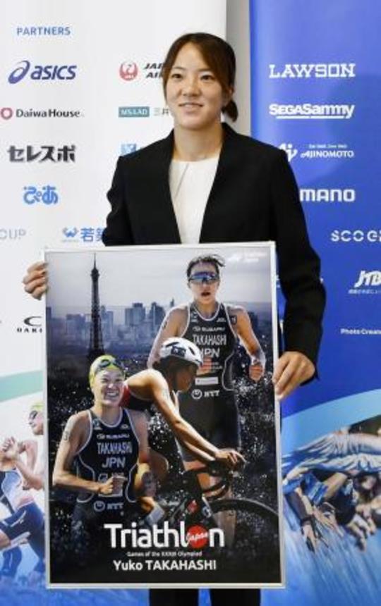 　現役引退の記者会見でパネルを手に写真に納まるトライアスロン女子の高橋侑子＝１１日、東京都新宿区