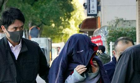 　家宅捜索に立ち会うため、捜査員に連れられて自宅に入る吉井辰夫容疑者（中央）＝２６日午前、福岡市早良区