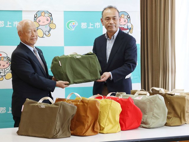 オリジナルマイバッグを披露する日置敏明市長（左）と森下政浩さん＝郡上市役所