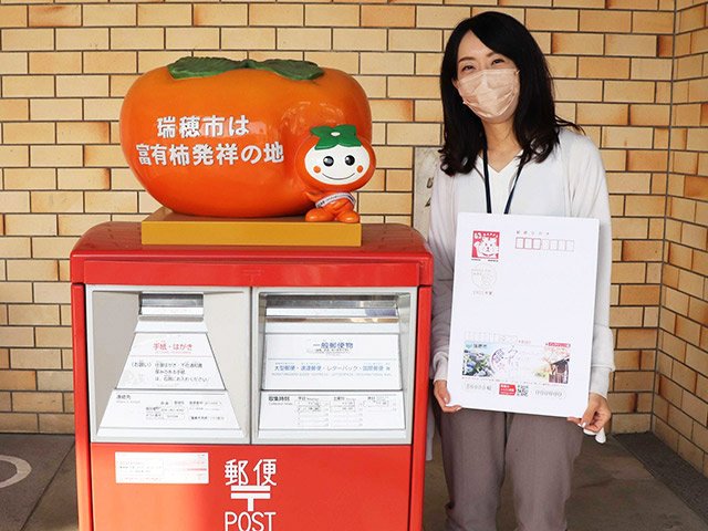 瑞穂市の広告付き年賀はがきの見本をＰＲする市職員＝同市役所