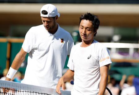 　男子シングルス２回戦で敗れた望月慎太郎（右）＝ウィンブルドン（共同）