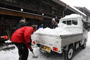 よけた雪を軽トラックの荷台に積む市民ら＝２４日午前１０時１７分、高山市上三之町