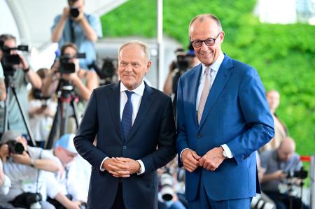 　ベルリンに到着したポーランドのトゥスク首相（左）を出迎えるドイツのメルツ首相＝２４日（ゲッティ＝共同）